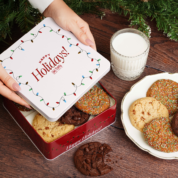 hands opening a red and white tin of cookies