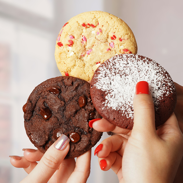 each valentines day mix flavor being held up in a hand, cheersing