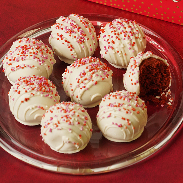 two red velvet cookie truffles, with one cut open to show the inside